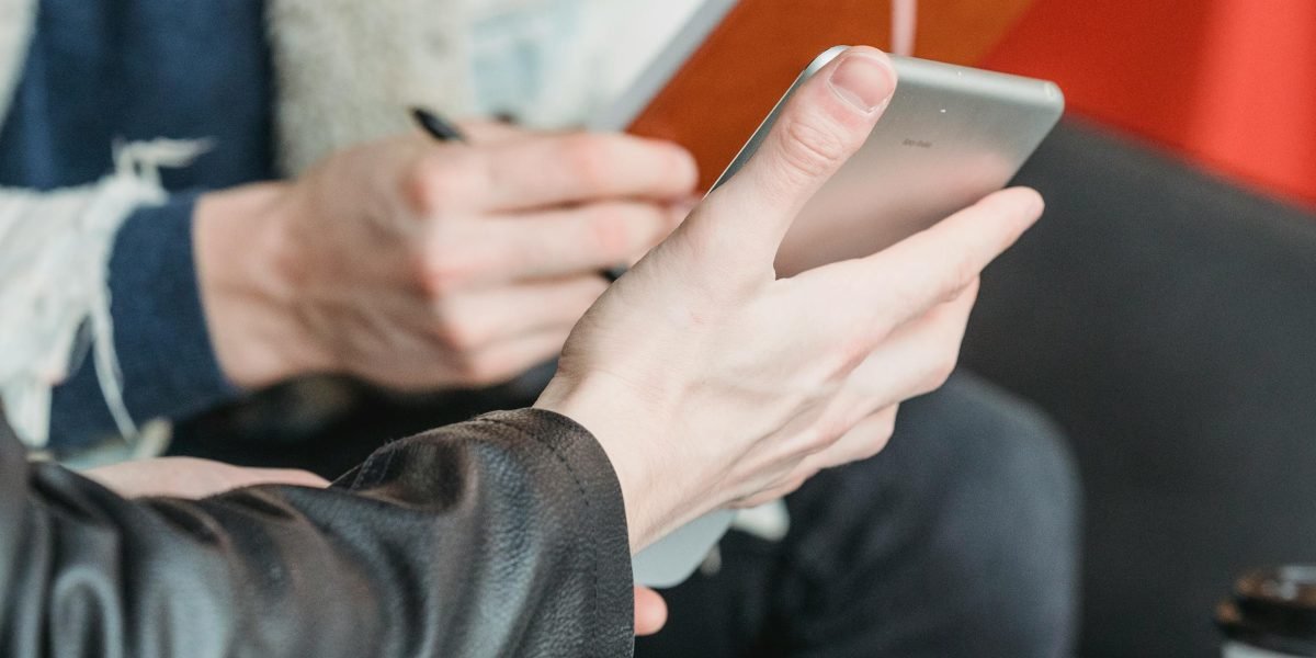 A person reviewing flashcards on a mobile device in a casual setting like a coffee shop.