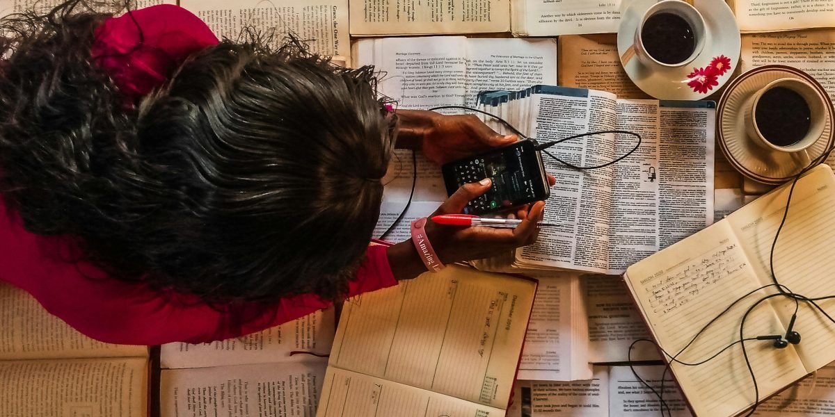 A person is easily distracted by their phone or surrounding digital notifications while trying to study, highlighting a common modern challenge.