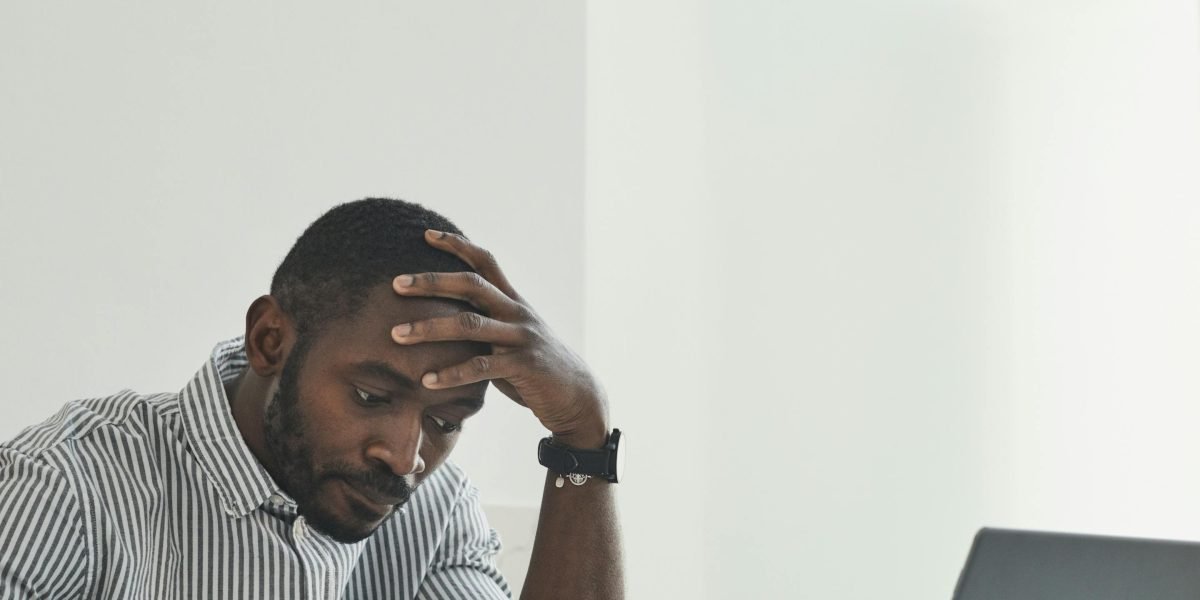 A person at a desk surrounded by digital distractions, highlighting the common challenge of maintaining focus in the modern world.