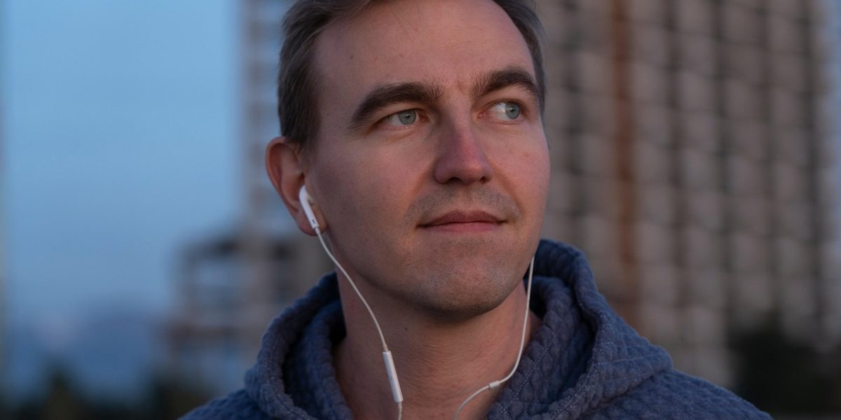 A person listening intently to an audiobook while performing light household chores, demonstrating reduced visual multitasking.