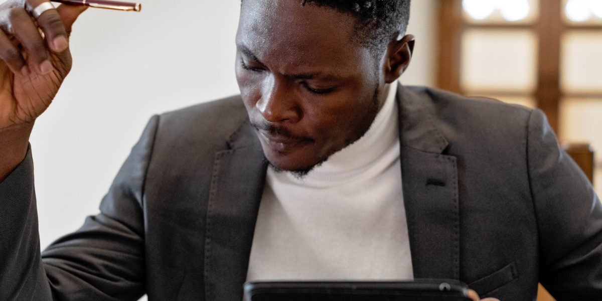 A person looking distractedly at a tablet, symbolizing the challenge of maintaining concentration during digital reading.