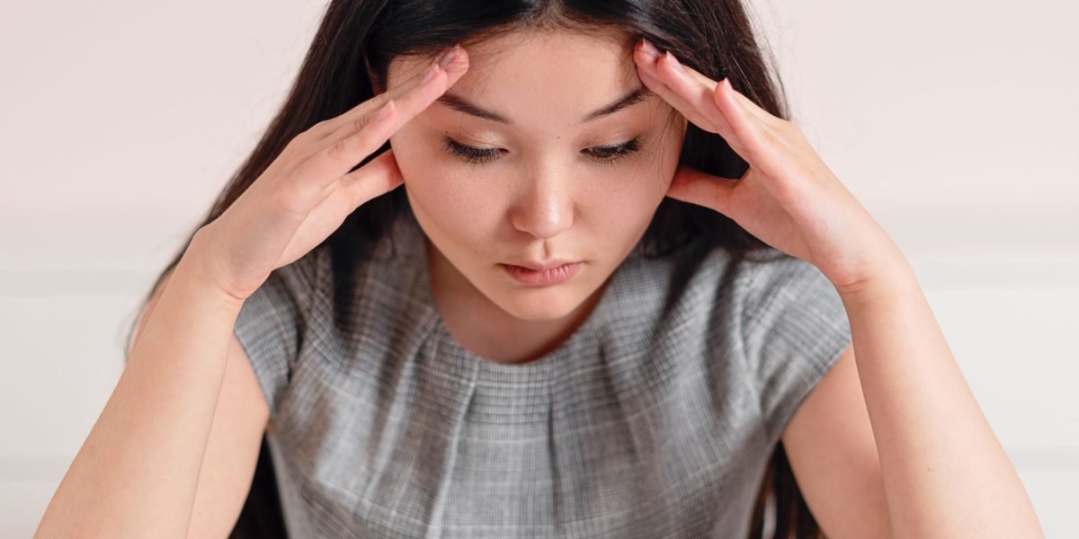 A person looking stressed while holding a phone, symbolizing the feeling of being overwhelmed by digital distractions.