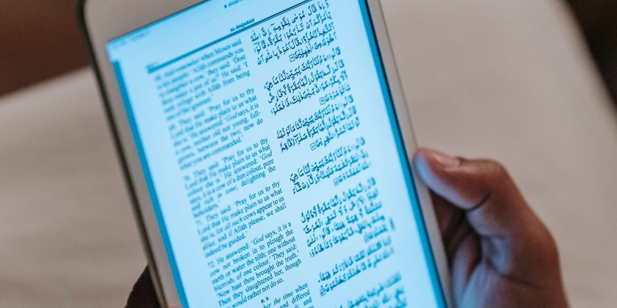 A person engrossed in reading on an e-reader, demonstrating focused and relaxed engagement.