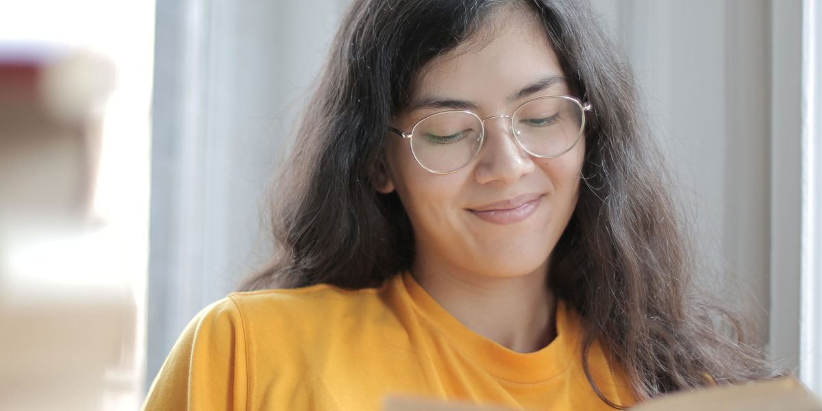 A person deeply engaged in reading on a digital device, symbolizing undisturbed focus.