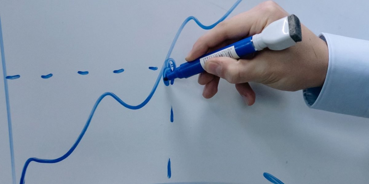 A professional looking thoughtfully at a whiteboard or screen displaying productivity data and insights.