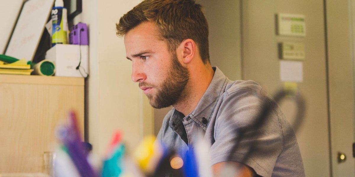 A person in a focused setting, yet visibly distracted or struggling to maintain concentration, representing the impact of digital interruptions.