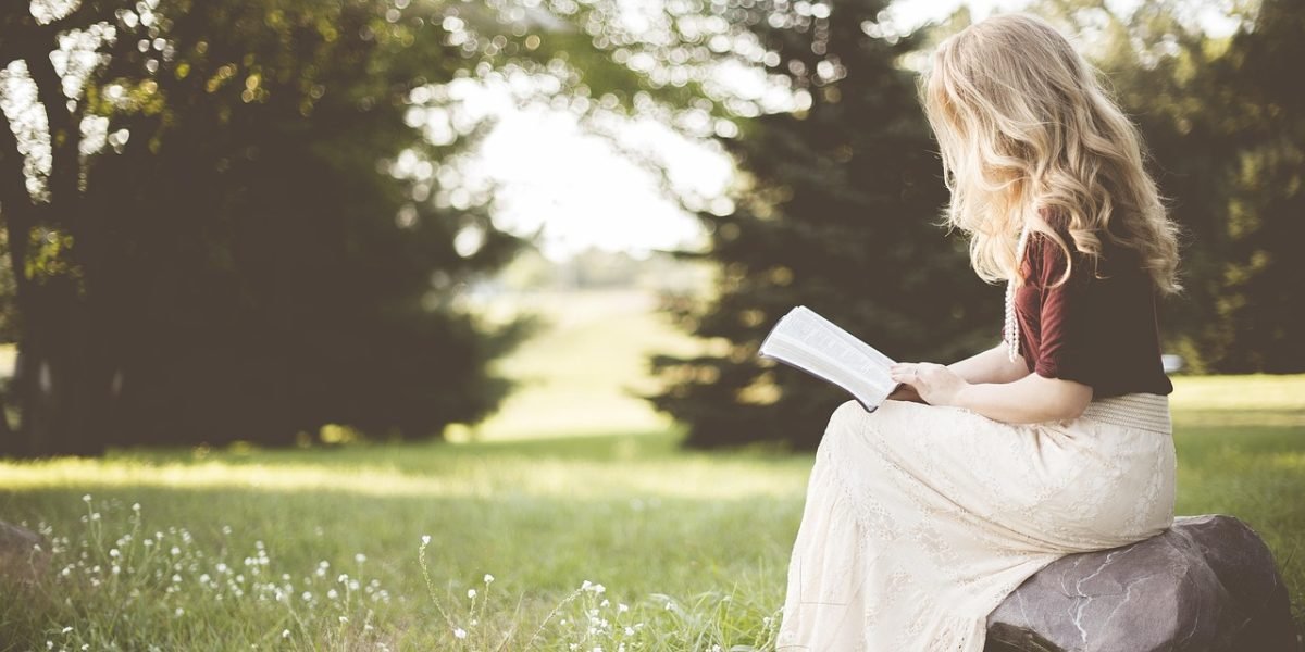 A person reading quietly in a peaceful setting, symbolizing the sustained attention and focus developed through regular reading.