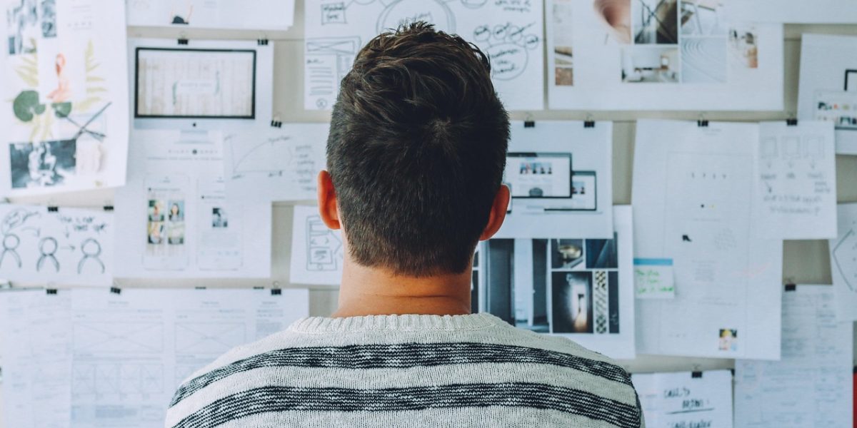A person actively planning their tasks or schedule on a whiteboard.