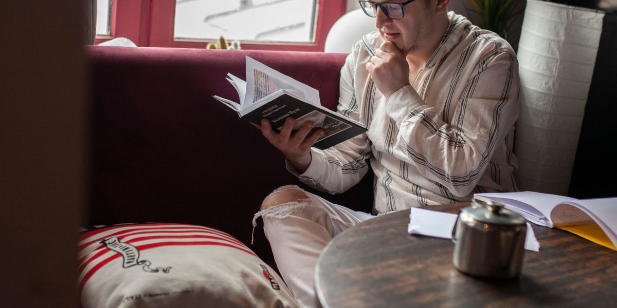 A person is engrossed in a book in a serene home environment, embodying deep, focused reading.