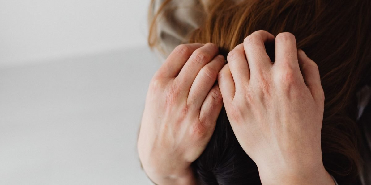 A person experiencing the common feelings of stress and overwhelm from a fast-paced, digitally saturated lifestyle.